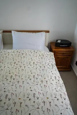 a bed with a white bedspread with flowers on it at Villa Gaia Novi Grad