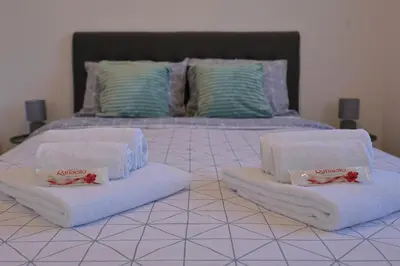 a bed with white towels on top of it at Kosta Boutique Apartment in Banja Luka