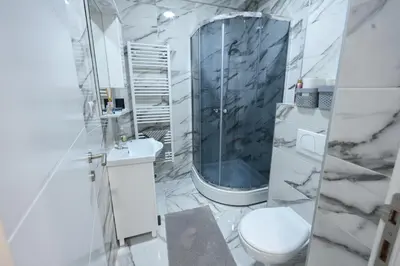a white bathroom with a shower and a toilet at Kosta Boutique Apartment in Banja Luka