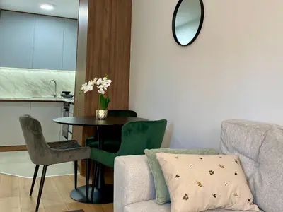 a living room with a table and a chair at FILIP Lux Apartman sa garažom in Doboj