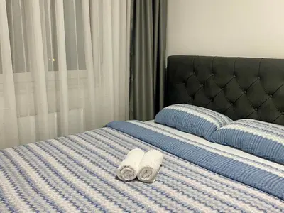 a bed with two towels sitting on top of it at FILIP Lux Apartman sa garažom in Doboj