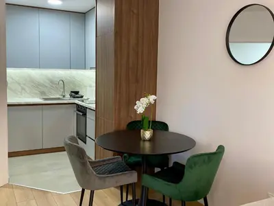 a kitchen and dining room with a table and chairs at FILIP Lux Apartman sa garažom in Doboj