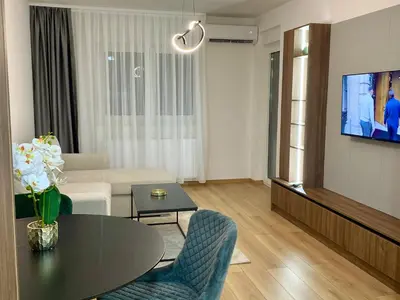 a living room with a table and a tv at FILIP Lux Apartman sa garažom in Doboj