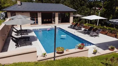 an overhead view of a swimming pool with umbrellas at Villa Bagrem - Villa with private pool in nature in Banja Luka