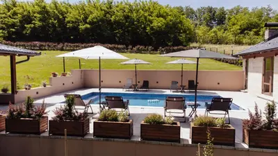 a swimming pool with patio furniture and umbrellas at Villa Bagrem - Villa with private pool in nature in Banja Luka