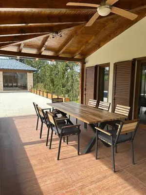 a large wooden table and chairs on a patio at Villa Bagrem - Villa with private pool in nature in Banja Luka