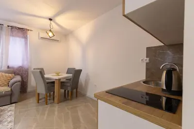 a kitchen and living room with a table and chairs at NolE Apartments in Visoko