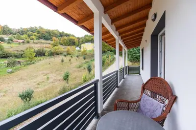 a porch with two chairs and a view of a field at NolE Apartments in Visoko