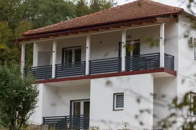 a white house with blue balconies on it at NolE Apartments in Visoko