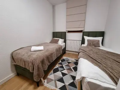 a bedroom with two beds and a rug at Semic apartments in Visoko