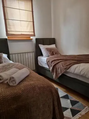 two beds sitting next to each other in a room at Semic apartments in Visoko