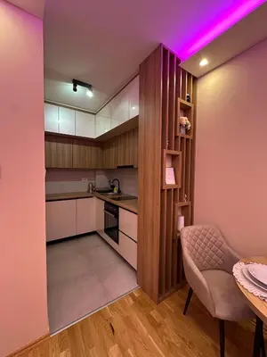 a kitchen with pink lighting and a table and a chair at Spa Apartman Love&Spa in Železnička Stanica Banja Luka Predgrađe