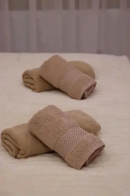 three brown towels on top of a bed at Spa Apartman Love&Spa in Železnička Stanica Banja Luka Predgrađe
