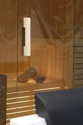 a room with a glass wall with a towel on a shelf at Spa Apartman Love&Spa in Železnička Stanica Banja Luka Predgrađe