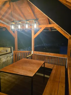 a wooden table on a balcony with lights at Vila Emani in Visoko
