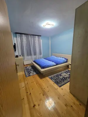 a bedroom with a bed with blue sheets in it at Vila Emani in Visoko