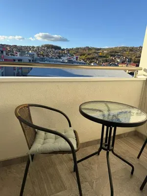 a table and chair on a balcony with a view at Kutak mira in Doboj