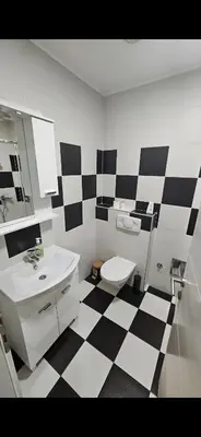 a bathroom with a black and white checkered floor at TM Studio Apartment Prijedor in Prijedor