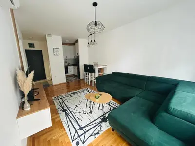a living room with a green couch and a table at Apartment Stepanova in Banja Luka