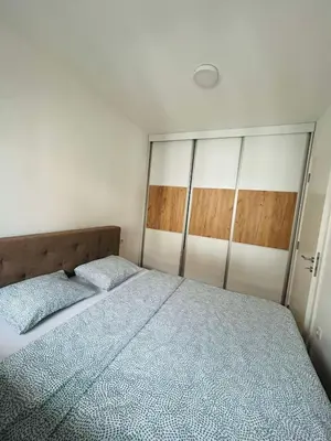 a bedroom with a large bed with a wooden headboard at Apartment Stepanova in Banja Luka