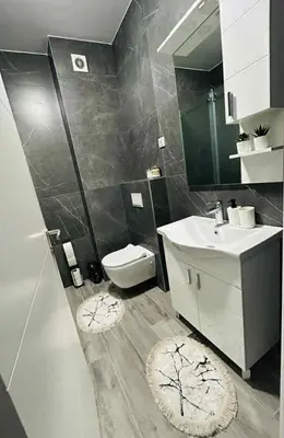 a bathroom with a sink and a toilet and a mirror at Apartment Stepanova in Banja Luka