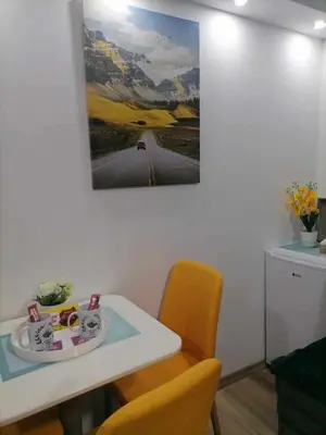 a room with a table and chairs and a painting on the wall at Apartments EDEN in Vlasic
