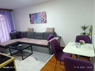 a living room with a couch and purple chairs at Apartments EDEN in Vlasic