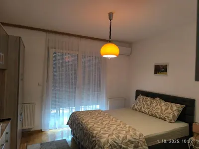 a bedroom with a bed and a large window at Dunja Doboj in Doboj