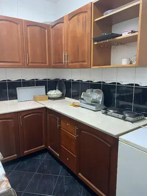 a kitchen with wooden cabinets and a counter top at Adna Art Apartment in Bihać