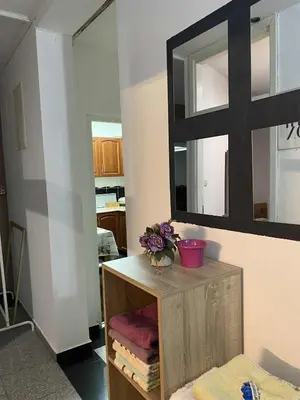 a bathroom with a mirror and a table with towels at Adna Art Apartment in Bihać