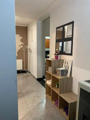 a living room with a shelf and a mirror at Adna Art Apartment in Bihać