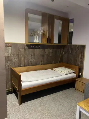 a bed in a room with a wooden wall at Adna Art Apartment in Bihać