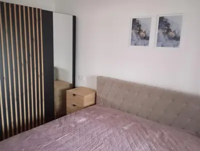 a bedroom with a bed and a dresser and a mirror at Apartman Teo in Banja Luka