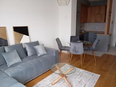 a living room with a blue couch and a table at Apartman Teo in Banja Luka