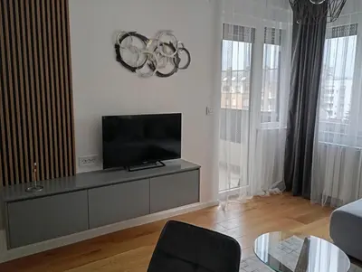 a living room with a flat screen tv on a cabinet at Apartman Teo in Banja Luka