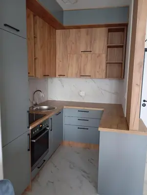a small kitchen with wooden cabinets and a sink at Apartman Teo in Banja Luka
