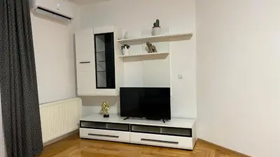 a living room with a television on a white entertainment center at Stan na dan Šamac in Bosanski Šamac