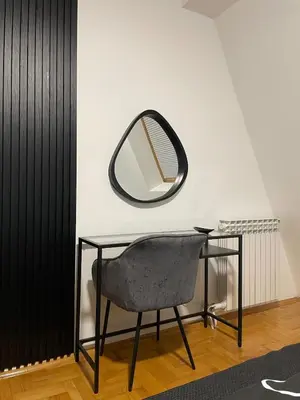 a desk with a chair and a mirror at Apartment in the center with free parking in Banja Luka