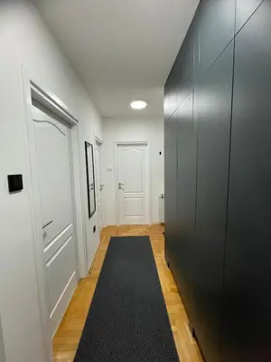 a hallway with a black rug and a door at Apartment in the center with free parking in Banja Luka