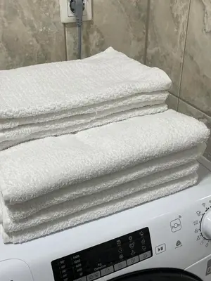 a stack of white towels sitting on top of a washing machine at Apartment in the center with free parking in Banja Luka