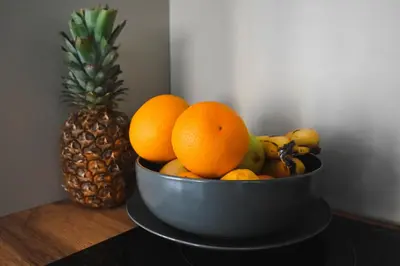 a bowl of fruit on a table next to a pineapple at Villa Fluviale in Jezero