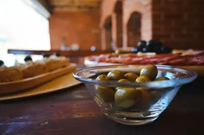 a glass bowl of olives on a table with pizzas at Villa Fluviale in Jezero