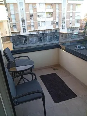 a balcony with a chair and a table and a window at Beatiful BL in Banja Luka