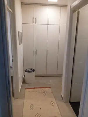 a hallway with white cabinets and a rug at Beatiful BL in Banja Luka