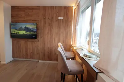 a room with a desk with two chairs and a window at Studio apartman Adria downtown in Banja Luka