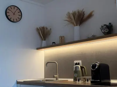 a kitchen with a sink and a clock on the wall at Studio apartman Adria downtown in Banja Luka