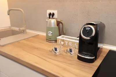 a kitchen counter with a coffee maker and two glasses at Studio apartman Adria downtown in Banja Luka