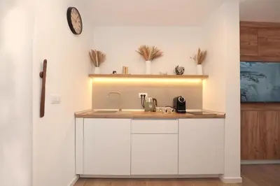 a kitchen with a sink and a clock on the wall at Studio apartman Adria downtown in Banja Luka