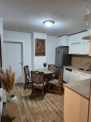 a kitchen with a table and chairs and a refrigerator at Apartment D in Krndija