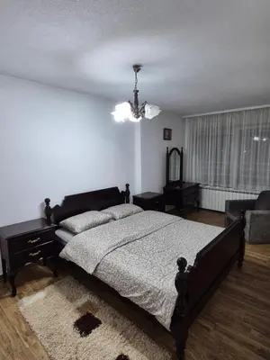 a bedroom with a large bed and a chandelier at Apartment D in Krndija